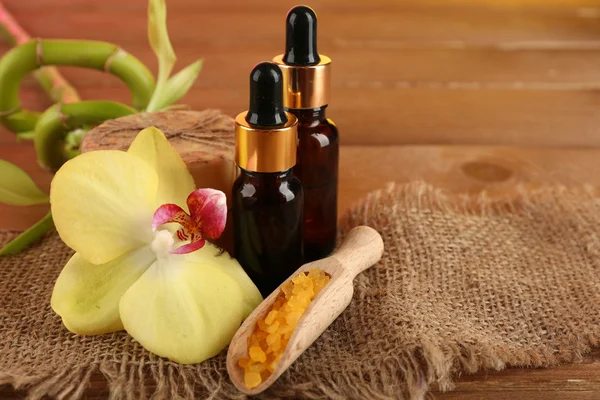 Spa composition with bottles of aromatic oils and bamboo on wooden background — Stock Photo, Image