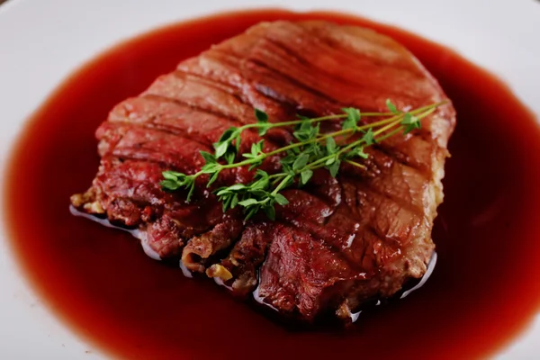 Grilled steak in wine sauce on plate close up — Stock Photo, Image