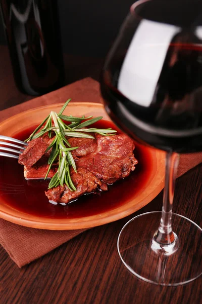 Copo de vinho com bife grelhado em molho de vinho sobre fundo escuro — Fotografia de Stock