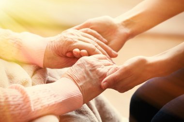 Old and young holding hands on light background, closeup clipart