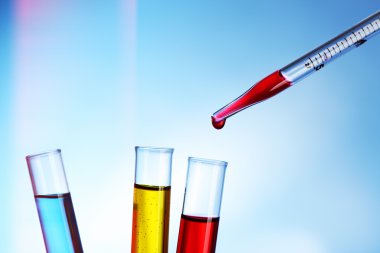 Pipet kırmızı sıvı test tüpleri mavi arka plan üzerinde bir ekleme