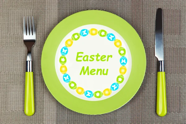 Piatto con testo "Menu di Pasqua", forchetta e coltello su fondo tovaglia — Foto Stock