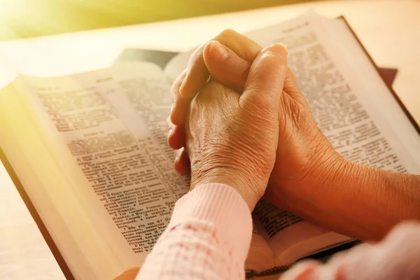 Mains de vieille femme avec Bible sur la table, gros plan — Photo