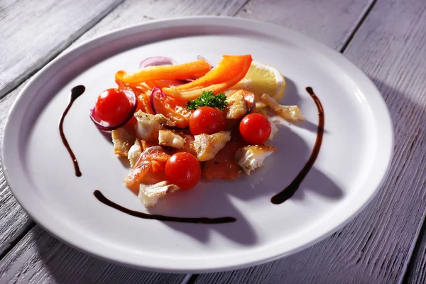 Ensalada de pescado fresco con verduras en plato sobre mesa de madera de cerca —  Fotos de Stock