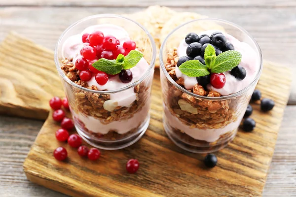 Postre en capas saludables con muesli y bayas en la mesa —  Fotos de Stock