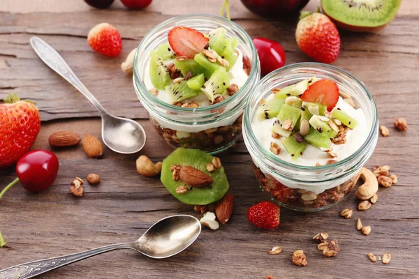 Friska skiktad dessert med müsli och frukt på bord — Stockfoto