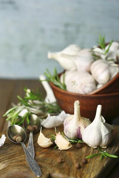 Rauwe knoflook en kruiden op houten tafel — Stockfoto