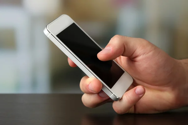 Mano celebración de teléfono inteligente móvil — Foto de Stock