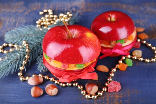 Rode appels gevuld met gedroogde vruchten met kaneel, takje van fir tree en noten op een houten tafel achtergrond kleur — Stockfoto