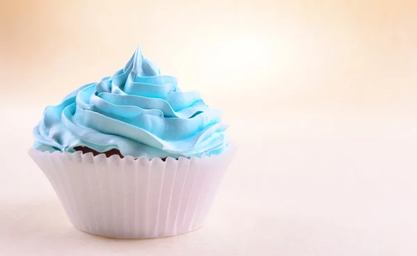 Delicioso cupcake no fundo bege — Fotografia de Stock