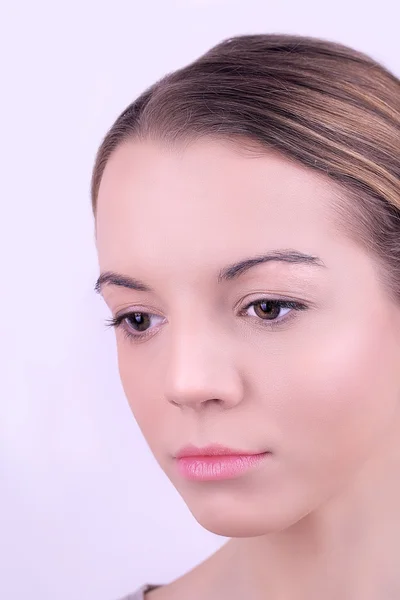 Appliquer le maquillage sur le visage féminin, sur fond blanc — Photo