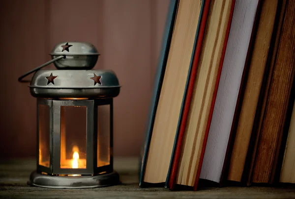 Knihy a dekorativní lampu na stůl a pozadí Dřevěná prkna — Stock fotografie