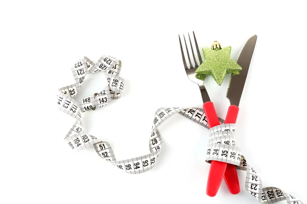 Measuring tape and cutlery with Christmas decoration isolated on white — Stock Photo, Image