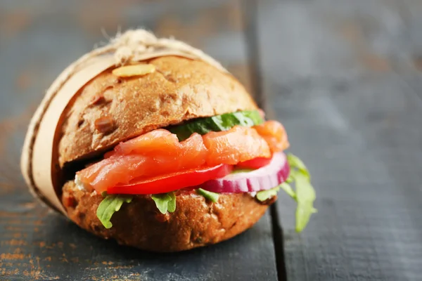 Sandwich con salmón sobre fondo de madera color — Foto de Stock