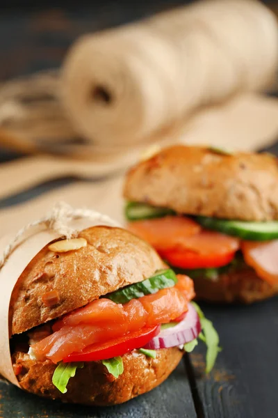 Sandwiches con salmón y verduras sobre fondo de madera — Foto de Stock