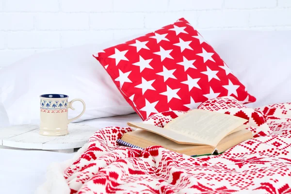 Book and cup of tea on bed close-up — Stock Photo, Image