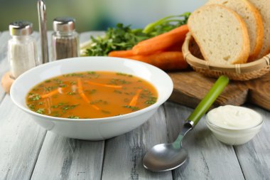 Havuç Çorbası, malzemeler ve ışık arka plan üzerinde renkli ahşap masa üzerinde otlar ile kompozisyon