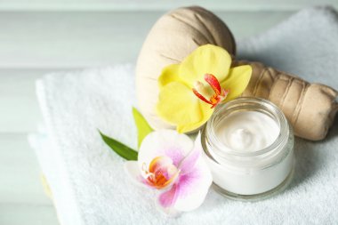 Spa uygulamaları ahşap arka plan üzerinde havlu üzerinde orkide çiçekli