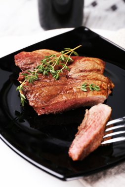 Ahşap arka plan üzerinde plaka üzerinde otlar ile biftek