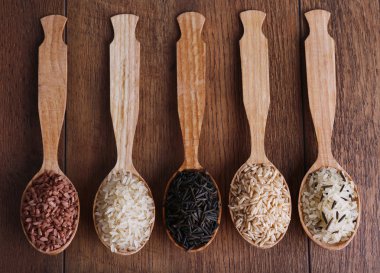 Ahşap zemin üzerine kaşık pirinç çeşitleri