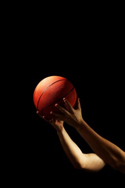 Koyu arka plan üzerinde topu ile basketbol oyuncusu