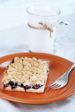 Reçel ve masa örtüsü ve renk ahşap arka plan üzerinde süt ile ev yapımı rendelenmiş pasta