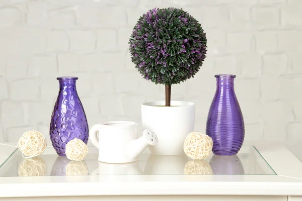 Interior with decorative vases and plant on table top and white brick wall background — Stock Photo, Image