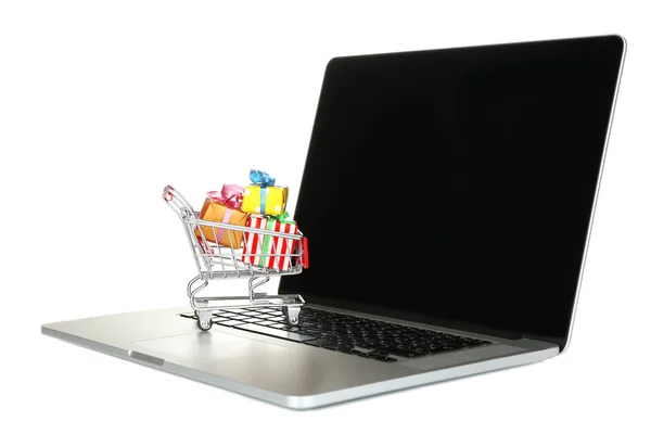 Laptop com carrinho de compras pequeno cheio de presentes isolados no fundo branco — Fotografia de Stock
