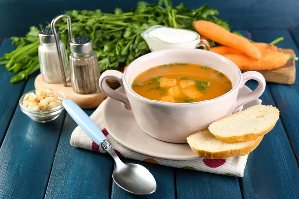Složení s mrkvová polévka, ingredience a byliny na barevné dřevěné pozadí — Stock fotografie
