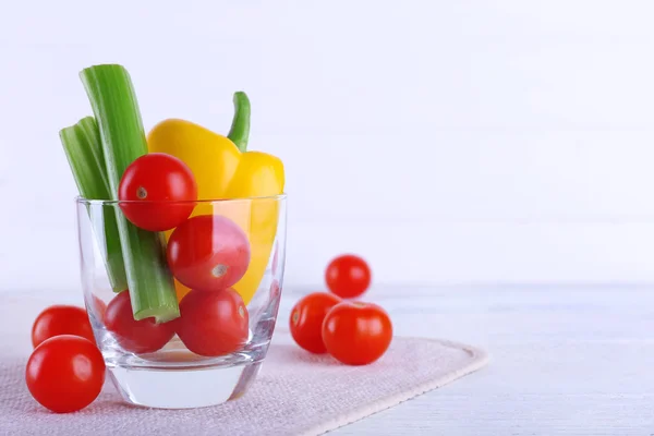 Grönsaker i glas på servett och träplankor färgbakgrund — Stockfoto