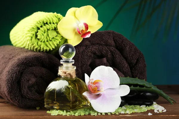 Tratamientos de spa con flores de orquídea sobre mesa de madera sobre fondo colorido — Foto de Stock