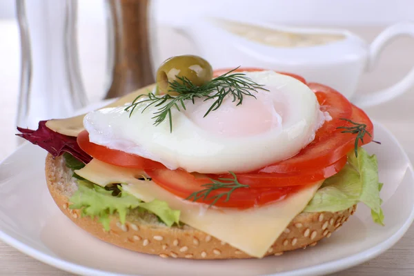 Sandwich with poached egg and vegetables on plate on wooden background — Stock Photo, Image