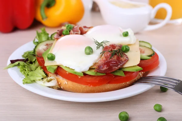 Сэндвич с яичницей, беконом и овощами на деревянном фоне — стоковое фото