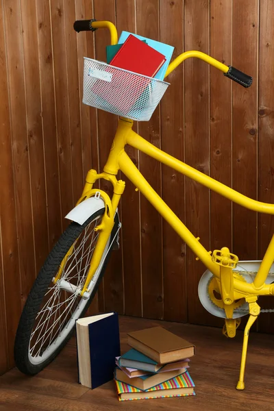 Bicicletta con libri su fondo parete in legno — Foto Stock