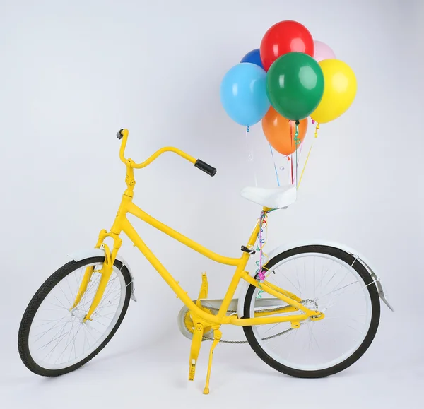 Bicicleta amarilla con globos aislados en blanco — Foto de Stock