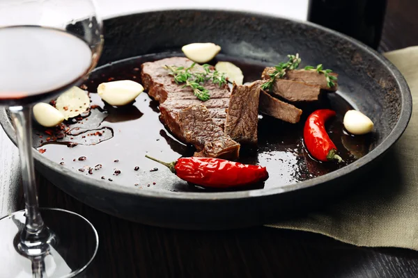 Verre de vin et steak dans la poêle sur la table fermer — Photo