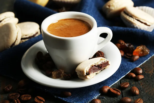 Macarons colorés doux et café en tasse sur fond de table en bois — Photo