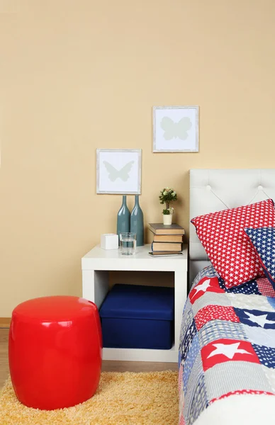 Moderne, farbenfrohe Schlafzimmereinrichtung mit Bett und Nachttisch, mit Designdetails auf hellem Wandhintergrund — Stockfoto