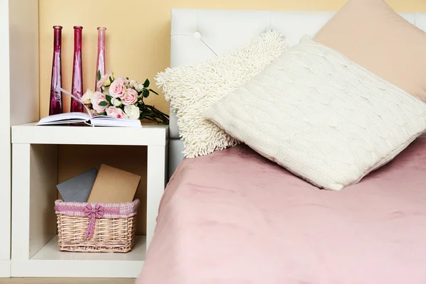 Современный красочный интерьер спальни с кроватью и тумбочкой, с деталями дизайна на светлом фоне стены — стоковое фото