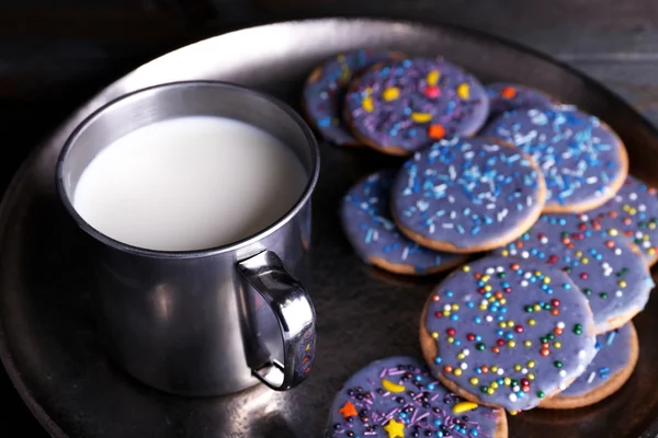 釉面的饼干与杯牛奶质朴木板背景上的金属托盘上 — 图库照片