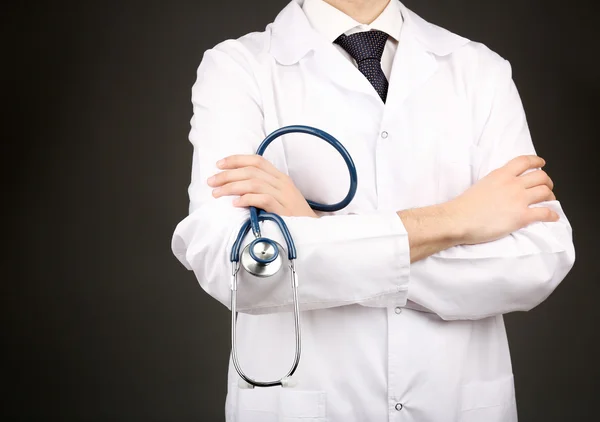 Médico masculino com estetoscópio em fundo cinza — Fotografia de Stock