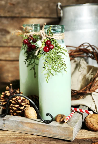 Botellas de leche fresca con decoración natural, sobre fondo de madera — Foto de Stock