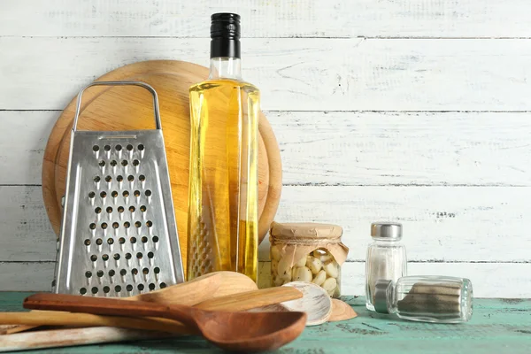 Utensilios de madera con rallador de metal y tabla de cortar en la mesa de color y el fondo tablones — Foto de Stock