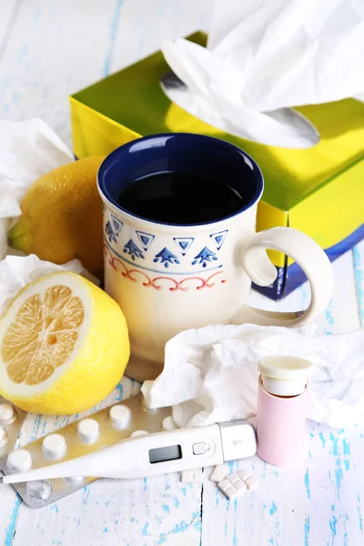 Горячий чай от простуды, таблетки и носовые платки на столе крупным планом — стоковое фото