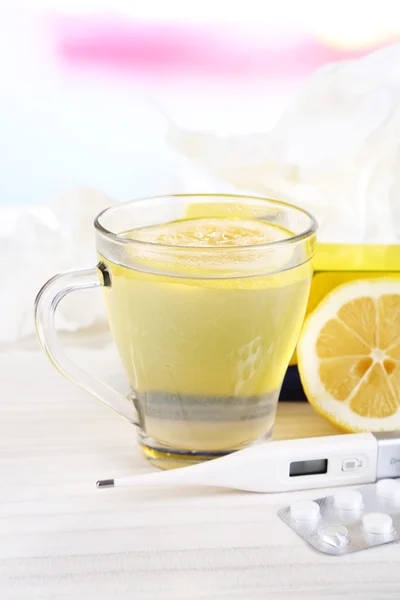 Té caliente para resfriados, píldoras y pañuelos en primer plano de la mesa — Foto de Stock