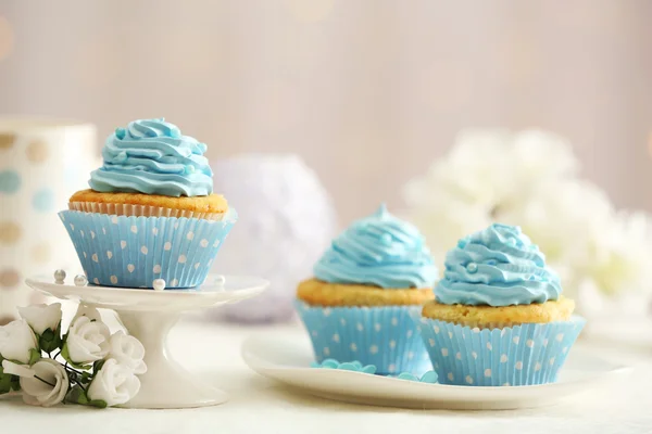 Νόστιμο cupcakes στο τραπέζι επάνω ελαφρύς υπόβαθρο — Φωτογραφία Αρχείου