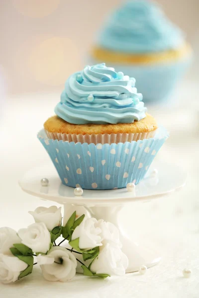 Deliciosos cupcakes na mesa no fundo claro — Fotografia de Stock