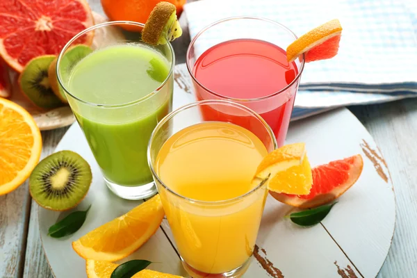 Jugos frescos con frutas en mesa de madera — Foto de Stock