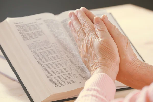 Mains de vieille femme avec Bible sur la table, gros plan — Photo