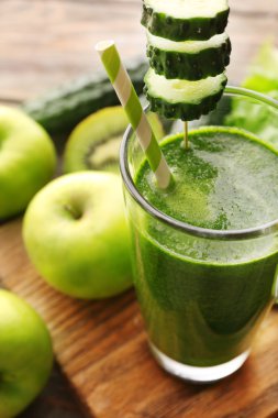 Meyve ve sebze kesme tahtası ve ahşap masa arka plan ile yeşil taze sağlıklı meyve suları